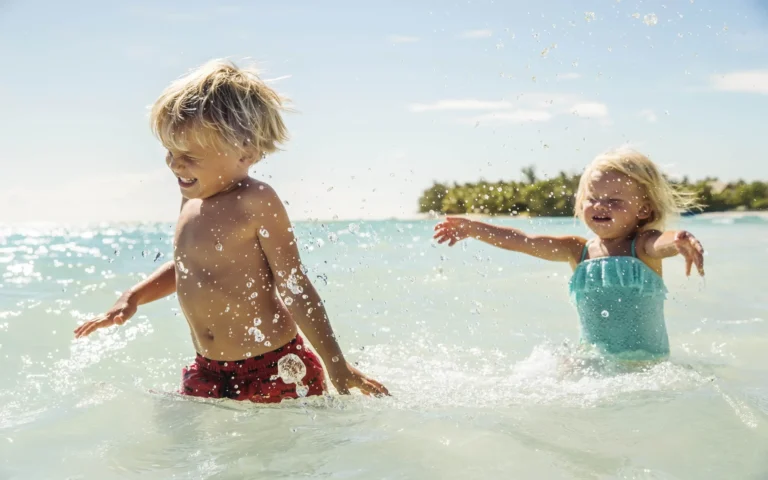 Children playing on the beach at One&Only Le Saint Géran, Mauritius — tropical white sand and turquoise water