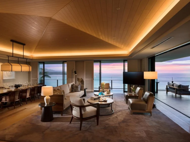 Suite or villa dining table and lounge area at dusk with wide sea views