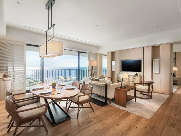 Suite dining table and living room with a balcony and sea view
