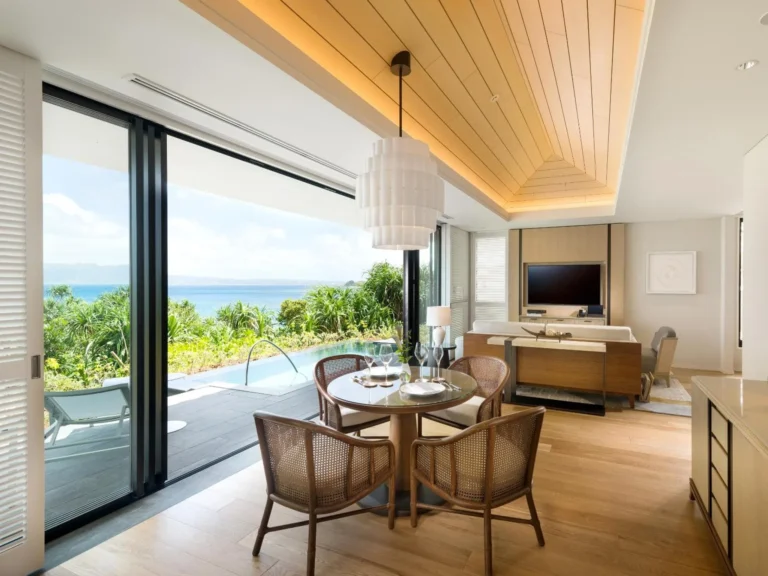 Villa terrace table set for dinner beside a private pool and sea