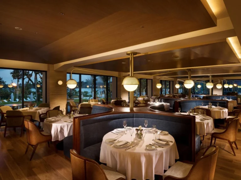 Steakhouse dining room with navy banquettes and round tables