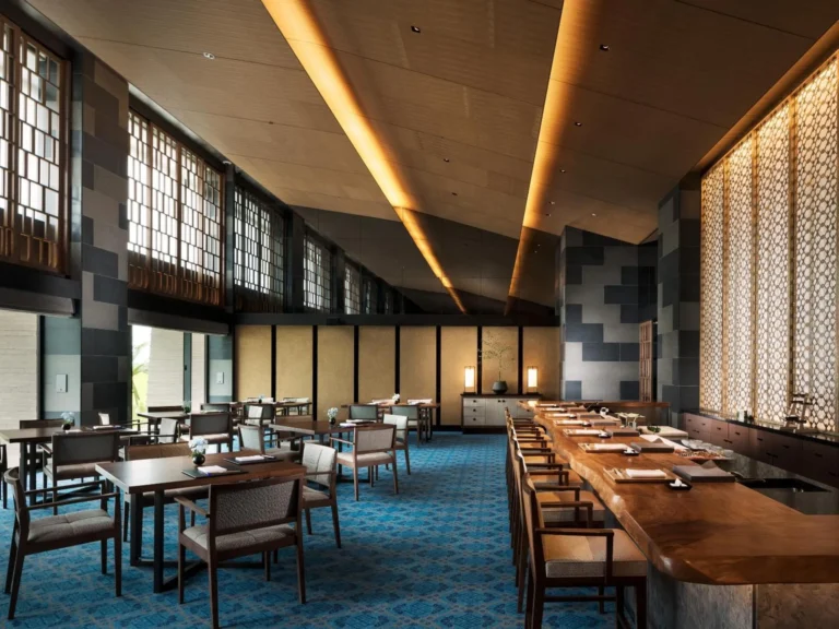 Japanese restaurant hall with wooden tables, screens and a blue patterned carpet