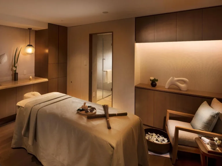 Spa treatment room with a massage bed and warm wooden panelling