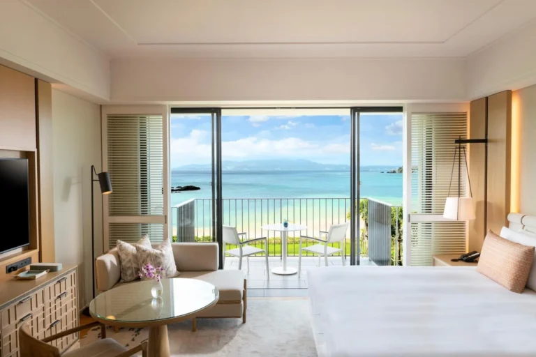Room with a sea-view balcony, a sofa and a bed in the foreground