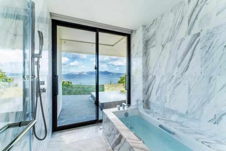 Marble bathroom with a deep tub in front of sliding doors to a garden terrace