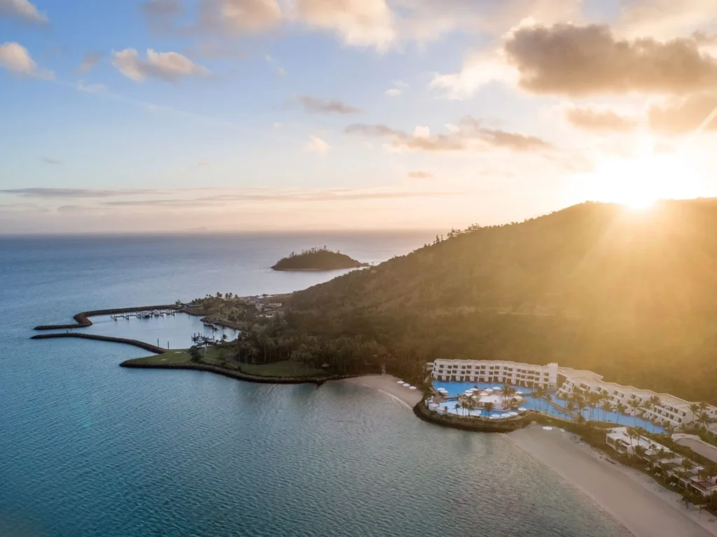 Aerial view at sunrise of the resort wings, pool and marina breakwater on Hayman Island