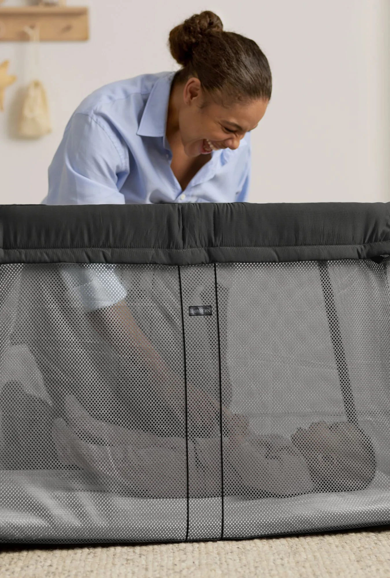 BabyBjörn Travel Cot Light carry bag placed beside luggage in an open car boot