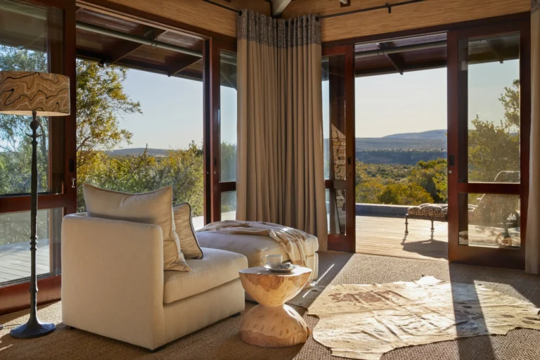The lounge of a suite at Kwandwe Ecca Lodge opening onto the deck and valley
