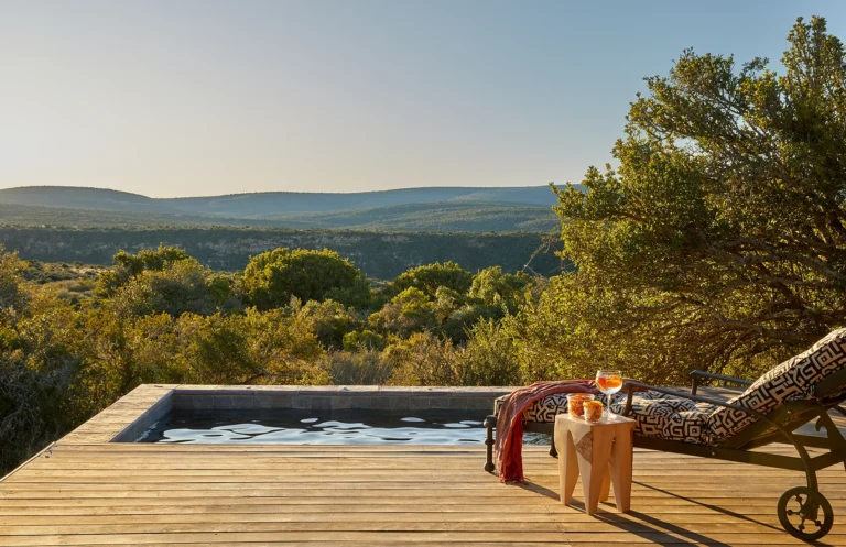 A plunge pool and sun lounger on a suite deck at Kwandwe Ecca Lodge overlooking the valley
