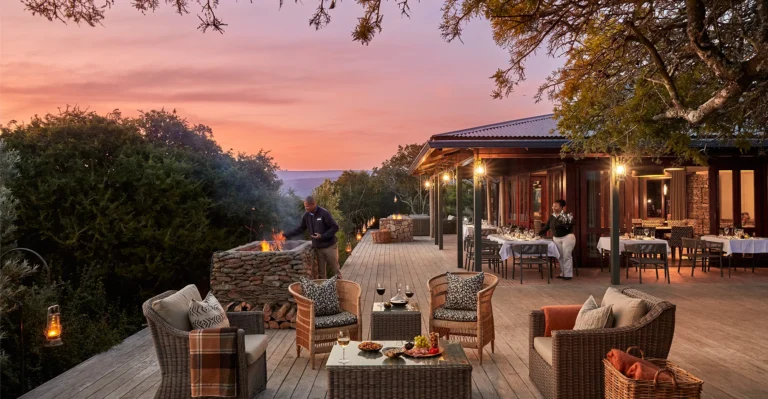 The main deck at Kwandwe Ecca Lodge at sunset with lanterns and seating