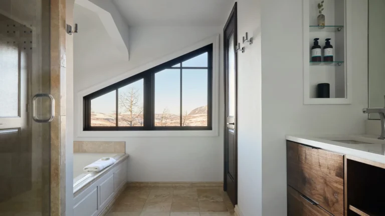 Residence bathroom with a glass shower, a soaking tub under a window and a wooden double vanity