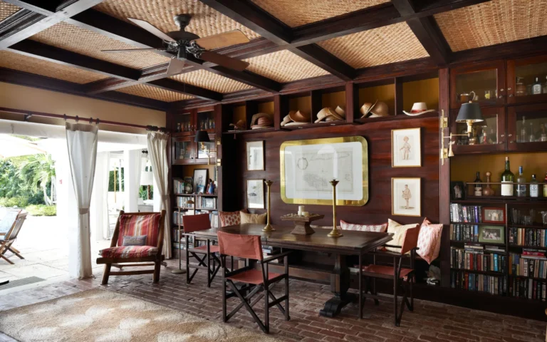 Wood-panelled library with bookshelves, a long table and folding chairs