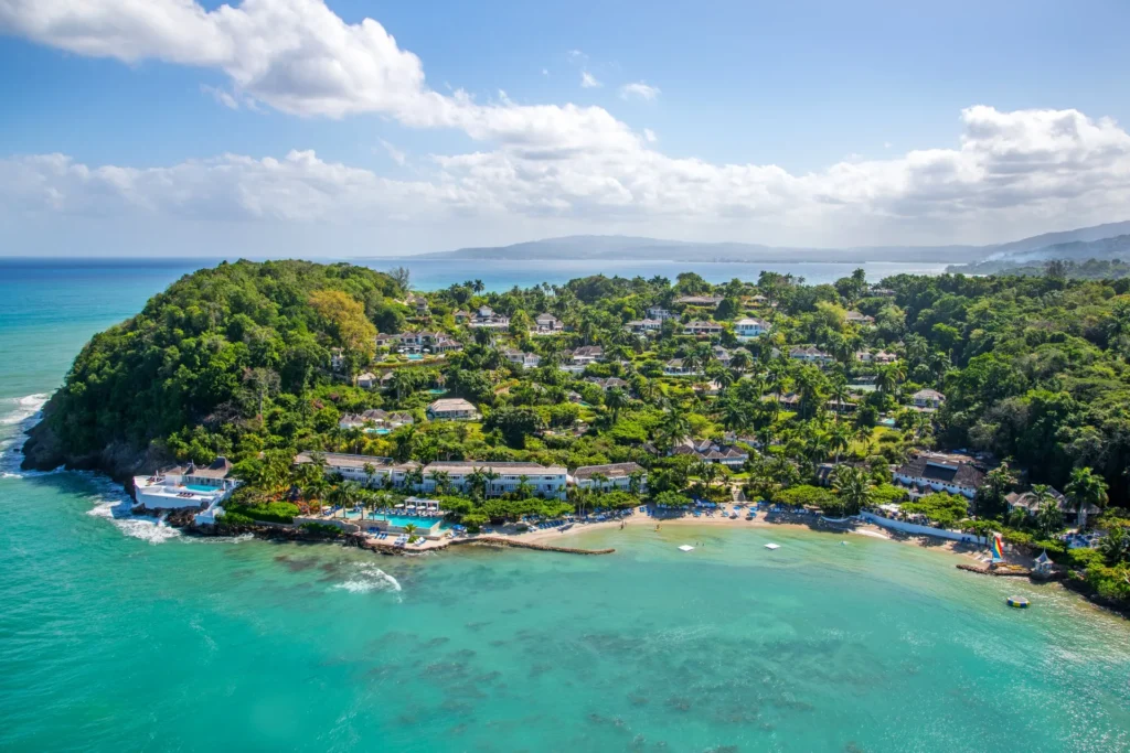 Aerial view of Round Hill's green peninsula and turquoise bay on Jamaica's north-west coast